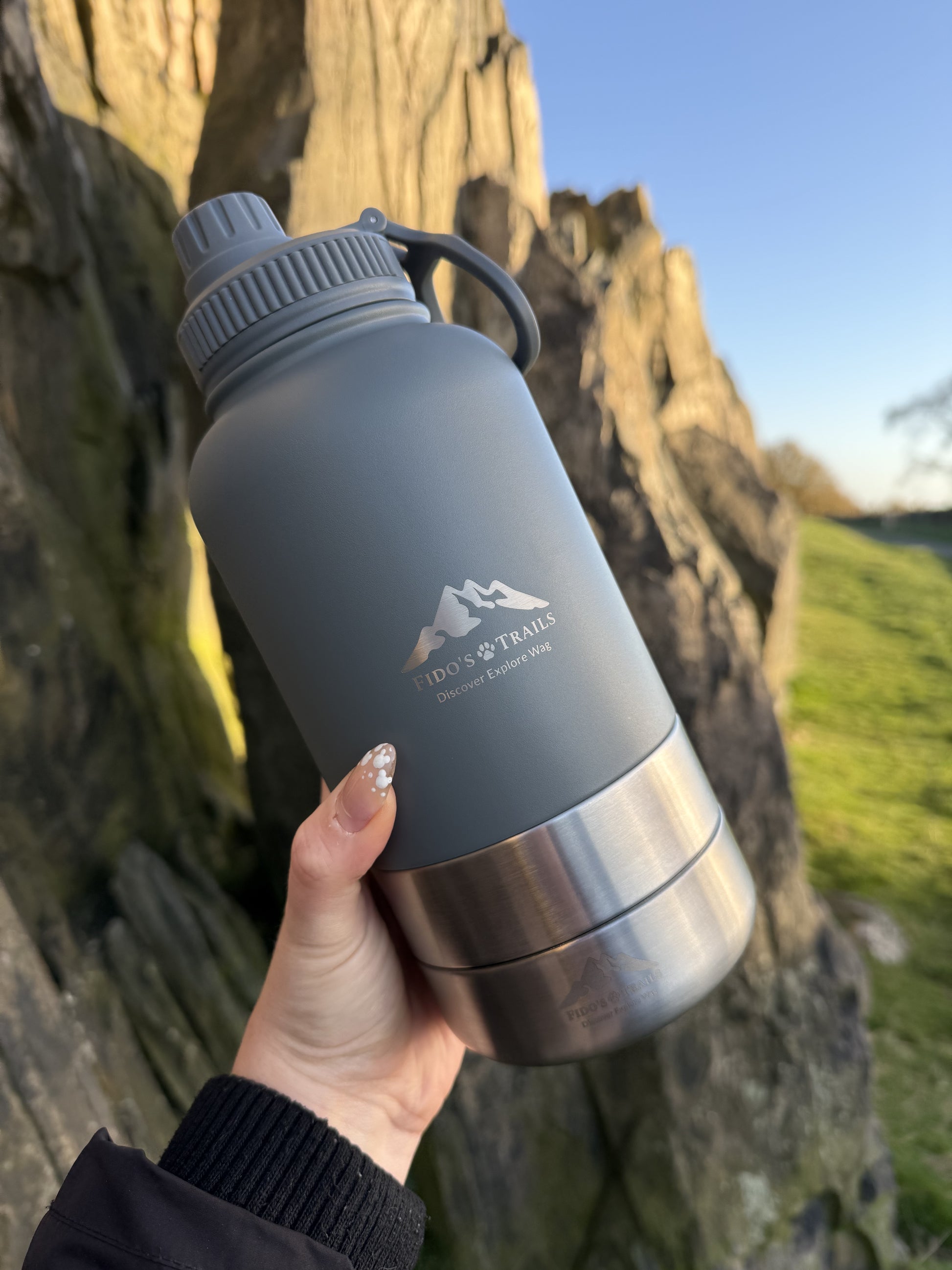 Mountain Grey 3-in-1 dog water bottle held during outdoor adventure walk