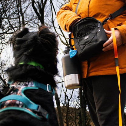 Dog owner reaching into tactical dog walking bag to give dog a treat – Fido’s Trails